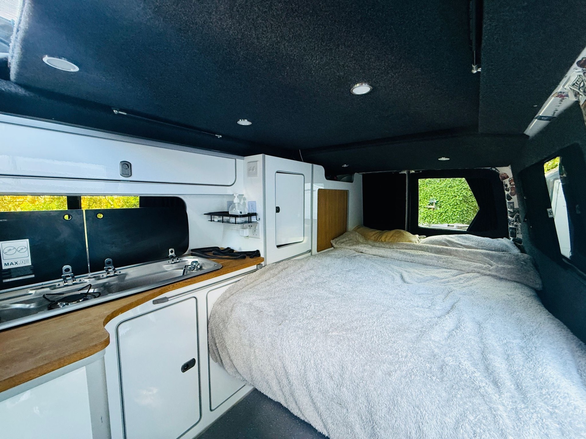 Inside OB13VAN showing the main bed and kitchen area